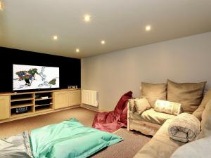 a living room with a couch and a flat screen tv at Chalet moderne 5* à Courchevel La Tania - 12 pers, jacuzzi, sauna, skis aux pieds, cheminée, cinéma - FR-1-575-154 in Courchevel