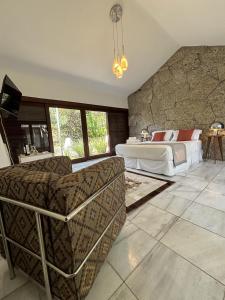 a bedroom with a bed and a stone wall at Les Jardins de Rio in Rio de Janeiro