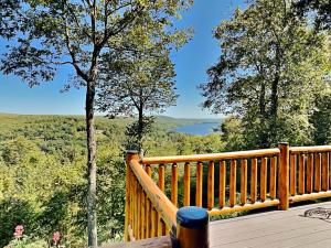 a wooden deck with a view of a lake at Magnificent Mountain Lodge in McHenry