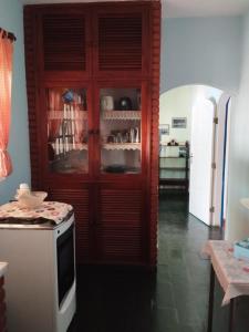 una cocina con un gran armario de madera con microondas en Cabo Frio, a melhor temporada, com menor preço., en Cabo Frío