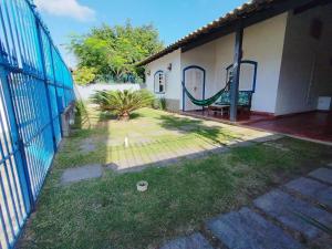 una cerca con un columpio delante de una casa en Cabo Frio, a melhor temporada, com menor preço., en Cabo Frío