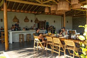 a group of people sitting at a table in a restaurant at 4 Coqueiros GURIU in Guriú