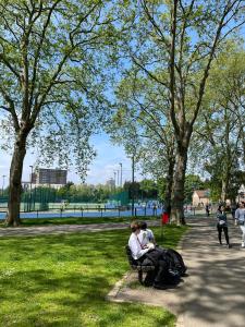 two people sitting on a bench in a park at Westminster Inn in London +85 photos