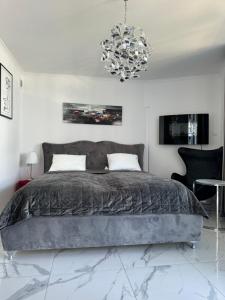 sypialnia z dużym łóżkiem i żyrandolem w obiekcie Apartament Kasprowicza 12A w Kołobrzegu