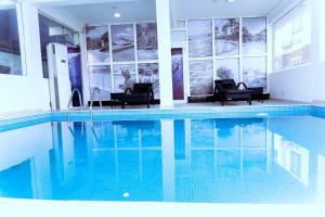 a house with a swimming pool with two chairs and a person sitting at 2-Bedroom Flat Lekki Phase 1 - Pool - Spa in Lekki