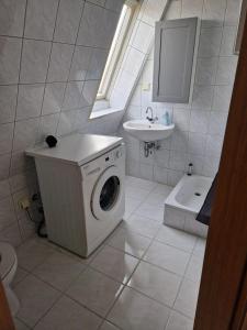 a bathroom with a washing machine and a sink at Wallaby-1-2-Personen in Brunsbüttel