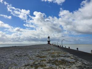 a lighthouse sitting on the end of a pier at Wallaby-1-2-Personen in Brunsbüttel +2 photos