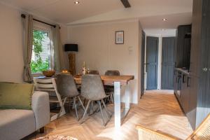 eine Küche und ein Esszimmer mit Tisch und Stühlen in der Unterkunft Forest Finest, luxe chalet met HOT TUB mooie overkapping en prachtige tuin met veel privacy in Hoenderloo
