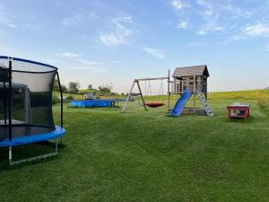 a playground with a slide and a swing at Bio-Ferienhof Köpf in Rieden am Forggensee