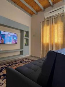 ein Wohnzimmer mit Fernseher und Sofa in der Unterkunft El Descanso II in Barrio Rivadavia
