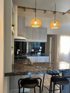 eine Küche mit einer Theke mit Stühlen und Lichtern in der Unterkunft El Descanso II in Barrio Rivadavia