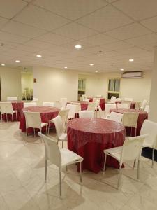 a room filled with tables and chairs with red table cloth at فندق مناير الاصول in Al Khansāk