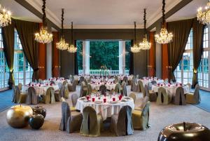 a banquet hall with tables and chairs and chandeliers at Hôtel Barrière L'Hôtel du Golf in Deauville +61 photos