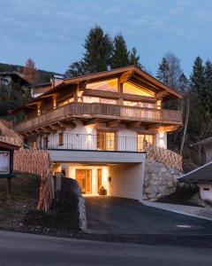 ein großes Holzhaus mit einer Einfahrt davor in der Unterkunft Chalet Wegmacher in Kirchberg in Tirol