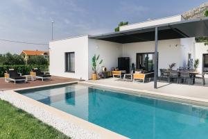 eine Villa mit Swimmingpool und ein Haus in der Unterkunft Villa Porto Recupera in Kaštela