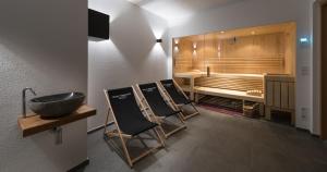 a bathroom with a tub and a sink and chairs at Chalet Wegmacher in Kirchberg in Tirol