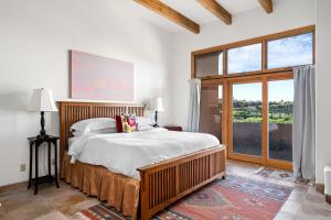 a bedroom with a large bed and a large window at Side-by-side Adobes, 9 Mi To Taos Ski Valley in Valdez