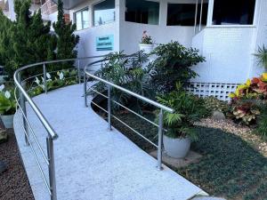 a metal railing in front of a building with plants at Bacutia, prédio frente ao mar! in Guarapari