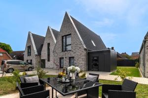 a house with a black roof and a black table at Ferienhaus Donnerkeil Fehmarn in Fehmarn