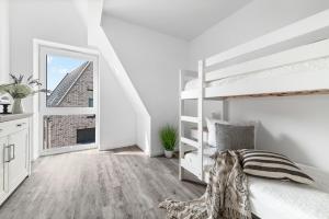 a white bedroom with a bunk bed and a window at Ferienhaus Donnerkeil Fehmarn in Fehmarn