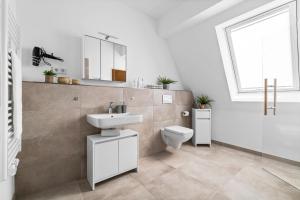 a bathroom with a sink and a toilet and a window at Ferienhaus Donnerkeil Fehmarn in Fehmarn +20 photos