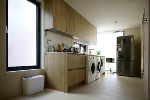 a kitchen with a refrigerator and a washer and dryer at CatNap Guesthouse in Busan