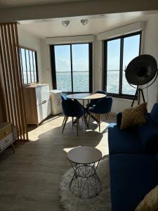 un soggiorno con un divano blu e un tavolo di Appartement moderne vue sur étang et montagne a Le Barcarès Altre 16 foto