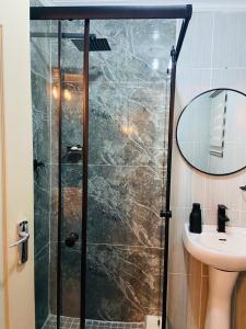 a shower with a glass door next to a sink at Lemao Properties/guest house in Johannesburg