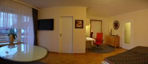 Zimmer mit einem Glastisch, einem Bett und einem Schreibtisch. in der Unterkunft Haus - Bonsai Bonsai Apartments I in Bad Pyrmont