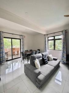 a living room with a couch and a table at 3-Bedroom Apt with Oceanviews, 1min Walk to Beach - NYHA2 in Flic-en-Flac