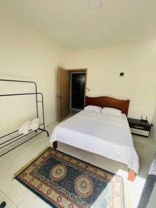 a bedroom with a white bed and a rug at 3-Bedroom Apt with Oceanviews, 1min Walk to Beach - NYHA2 in Flic-en-Flac