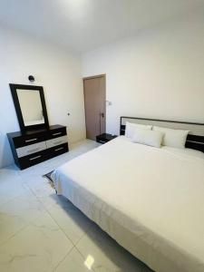a bedroom with a large white bed and a mirror at 3-Bedroom Apt with Oceanviews, 1min Walk to Beach - NYHA2 in Flic-en-Flac