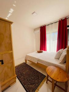 a bedroom with a bed and a window with red curtains at 3-Bedroom Apt with Oceanviews, 1min Walk to Beach - NYHA2 in Flic-en-Flac