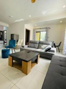 a living room with a couch and a coffee table at 3-Bedroom Apt with Oceanviews, 1min Walk to Beach - NYHA2 in Flic-en-Flac