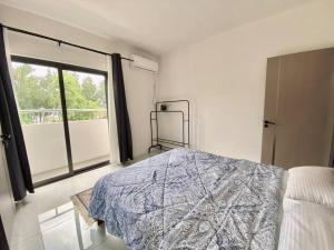 a bedroom with a bed and a large window at 3-Bedroom Apt with Oceanviews, 1min Walk to Beach - NYHA2 in Flic-en-Flac