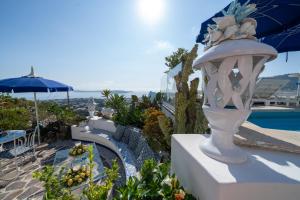 a white vase sitting on a wall next to a pool at Relais Bijoux Ischia in Ischia