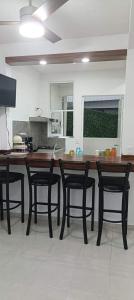 a kitchen with a wooden table and black chairs at Brisa y Mar in Ixtapa