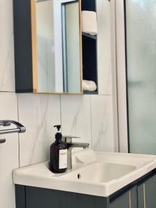 a bathroom sink with a bottle of soap on it at 3-Bedroom Apt with Oceanviews, 1min Walk to Beach - NYHA2 in Flic-en-Flac