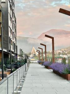 a rendering of a walkway between buildings with purple flowers at Cosy 2-rooms apartment in the city center in Tromsø