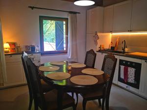 Ski Cottage في Semič: مطبخ مع طاولة وكراسي خشبية ومطبخ مع نافذة