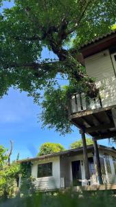 a house with a balcony and a tree at Croc Camp in Lat Krabang