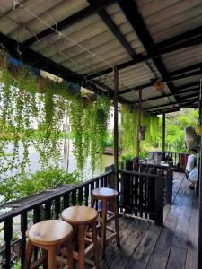 a porch with two stools and a table and chairs at Croc Camp in Lat Krabang