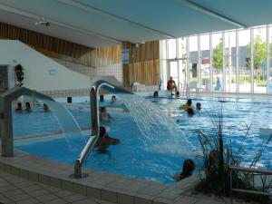 a group of people in a swimming pool at Gîte La Grenouillère in Esquéhéries