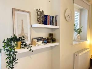 a room with shelves with books and a picture of the eiffel tower at Lux Balcony Penthouse Room Basingstoke Hospital 2min drive and walkable in Basingstoke
