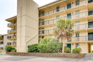 a building with a palm tree in front of it at Oceanfront Atlantic Beach Condo with View! in Atlantic Beach