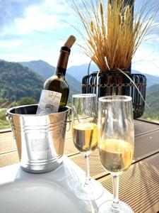 two wine glasses and a bottle of wine in a bucket at 17HILLS Cottage in Acharistsqali