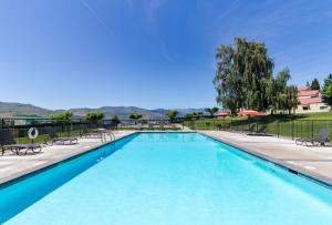 a swimming pool with chairs and umbrellas at Lake Chelan Shores: Lakeside Luxury #19-5 in Chelan