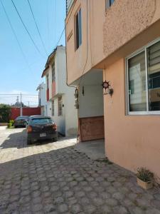 a car is parked next to a building at Rento casa por día, semana o mes in San Juan Xilotzingo