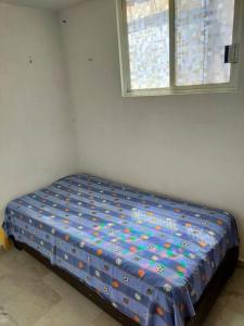 a bed sitting in a room with a window at Rento casa por día, semana o mes in San Juan Xilotzingo +5 photos