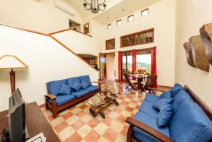 a living room with blue couches and a table at Casa Santalegria in San Juan del Sur